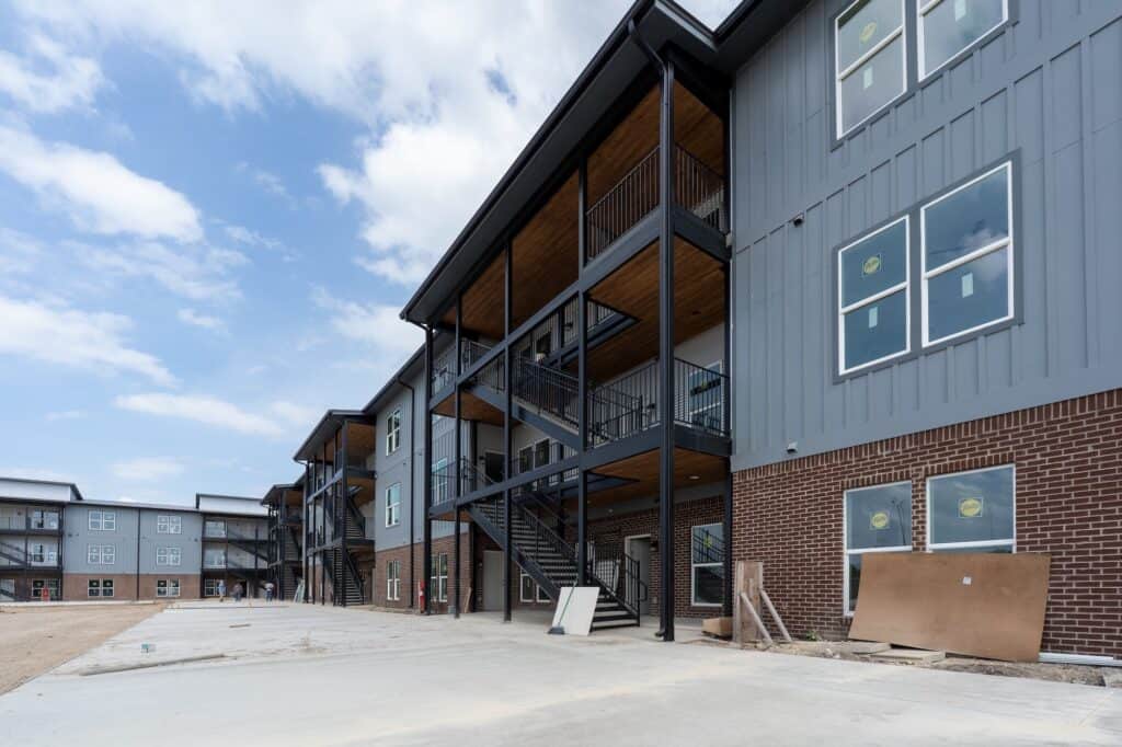 Modern apartment building exterior at The Exchange Apartments with multiple balconies.